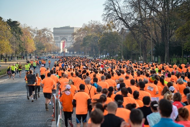 Deux femmes souriantes et un homme autour du sujet de la cause du cancer de la prostate au départ d'une course caritative.